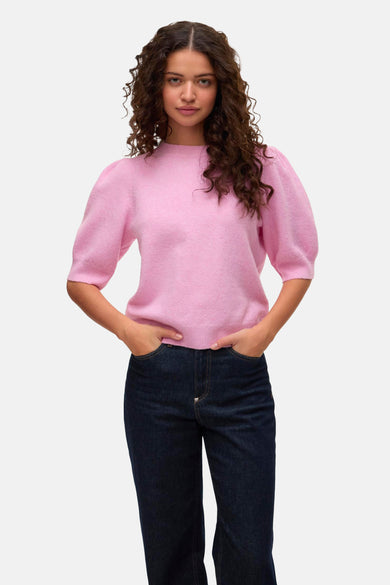 T-shirt rose à col rond de VERO MODA®, avec des manches courtes, associé à des jeans foncés et des chaussures plates.