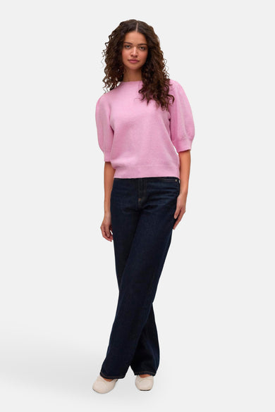 Roze trui met ronde hals van VERO MODA®, met korte pofmouwen, gecombineerd met donkere jeans en platte schoenen.
