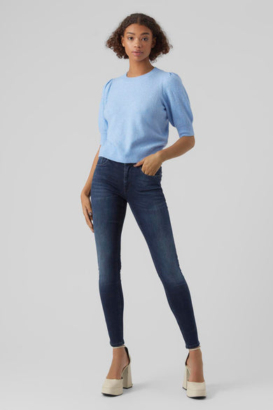 Pull bleu avec col rond de VERO MODA, avec manches courtes bouffantes, combiné avec un jean foncé et des talons beige.