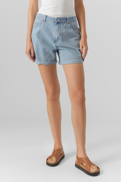 Short en denim bleu clair de VERO MODA, avec des jambes relevées et une apparence décontractée, associé à des sandales en cuir.