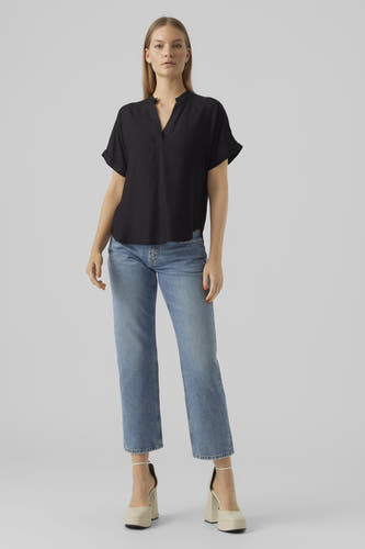 Chemisier noir à manches courtes de VERO MODA®, vu de dos, associé à un jean bleu et des talons beiges.