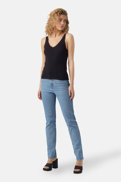 Top noir VERO MODA avec bretelles spaghetti, porté avec un jean bleu.