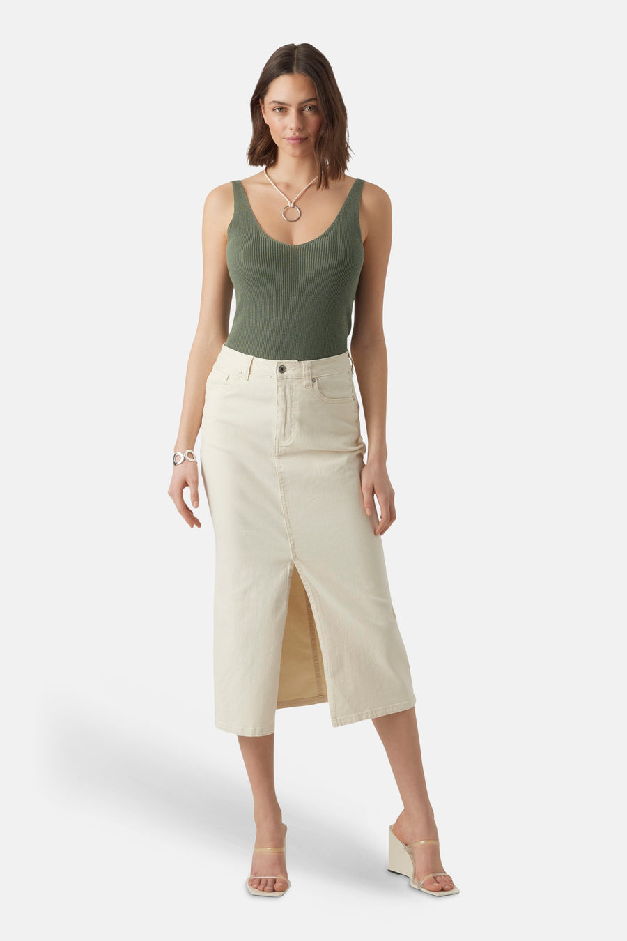 Groene top van VERO MODA, met spaghettibandjes en een ribgebreide textuur, gecombineerd met een rok en accessoires.
