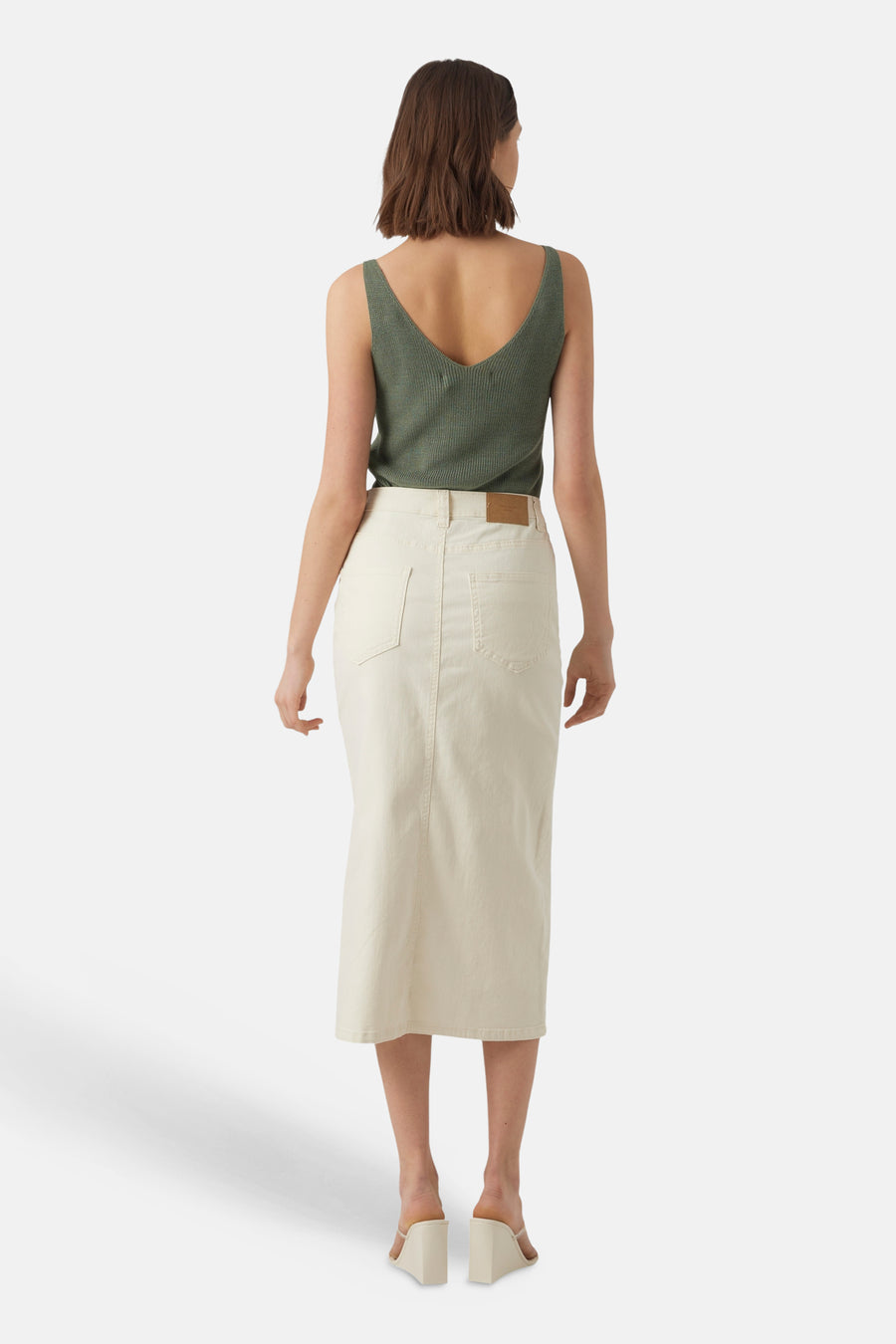 Haut vert à fines bretelles de VERO MODA, vu de dos, combiné avec une jupe blanche.