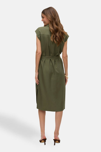 Vrouwenmodel in olijfgroene jurk met riem en hakken, achterkant.