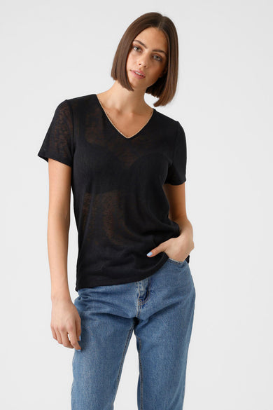 T-shirt noir à manches courtes de VERO MODA, avec un décolleté en V et porté avec un jean bleu et des talons hauts.