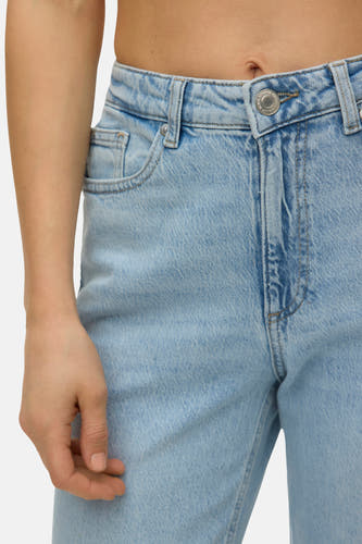 Jean droite bleu clair de VERO MODA, vue rapprochée avec une taille et une main.