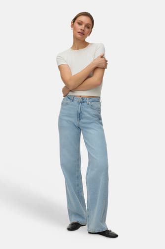 Jean droit bleu clair de VERO MODA®, combiné avec un t-shirt blanc et des chaussures noires.