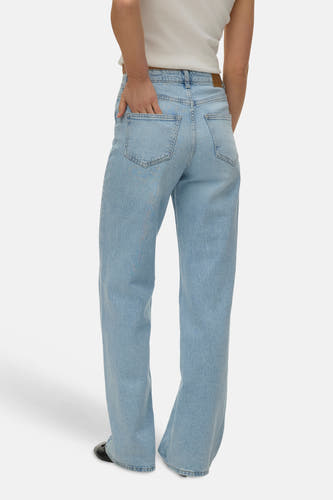Jean droit bleu clair de Vero Moda, avec poches arrière et une main dans une poche.