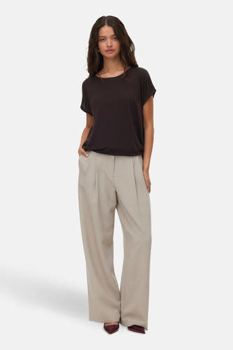 T-shirt marron à manches courtes de VERO MODA, associé à un pantalon beige avec des jambes larges et des chaussures pointues.