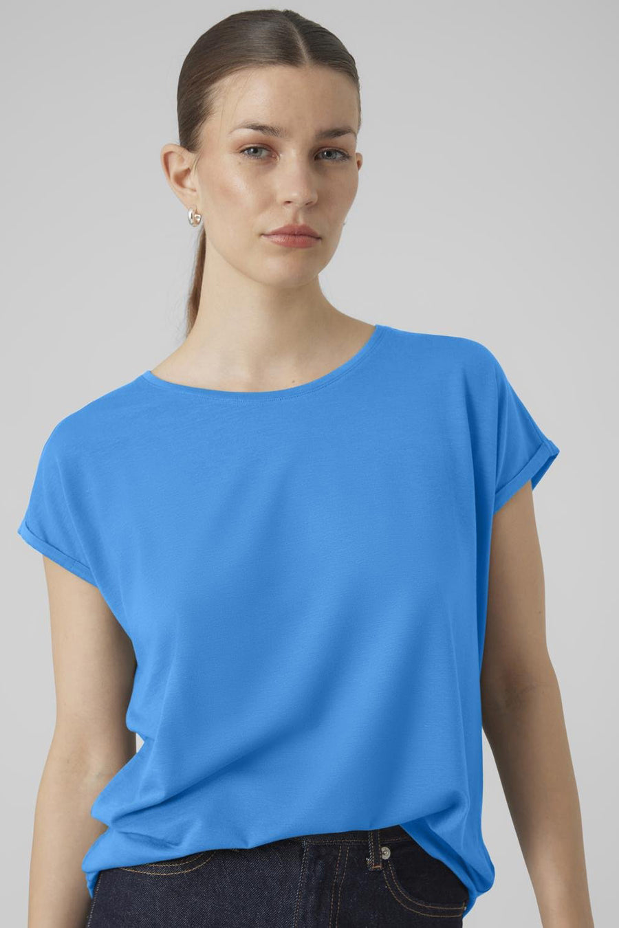 T-shirt bleu à manches courtes de Vero Moda, tissu uni, porté avec un jean bleu marine.