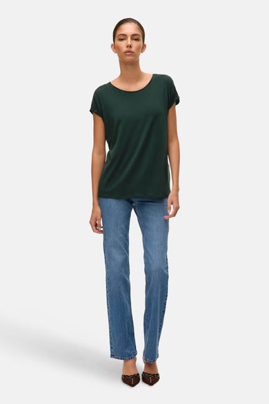 Groen T-shirt met korte mouwen van VERO MODA®, gedragen met blauwe jeans en bruine schoenen.
