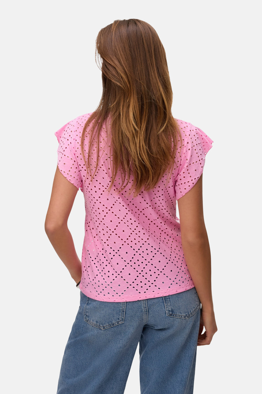 T-shirt rose à manches courtes de VERO MODA®, avec un motif ajouré, porté avec un jean bleu, vue arrière.
