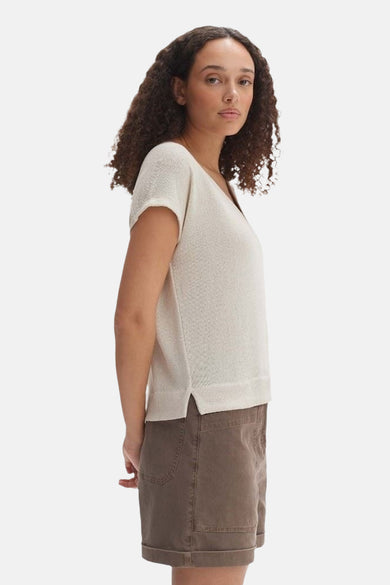 Blouse écru à manches courtes d'OPUS, avec une légère texture et portée avec des shorts bruns.