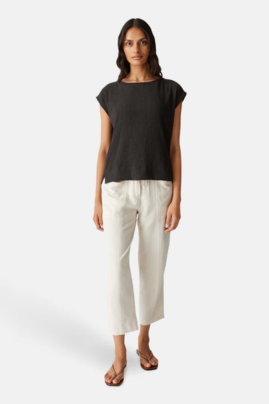 Blouse sans manches brune d'OPUS, avec une subtile texture et associée à un pantalon crème.