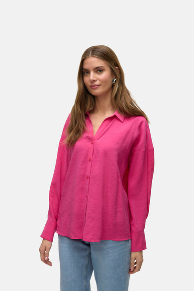 Chemise rose à longues manches de Vero Moda, avec une texture lisse et des boucles d'oreilles couleur argent.