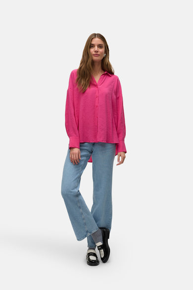 Chemise rose à longues manches de VERO MODA, portée avec des jeans bleus et des loafers noirs.