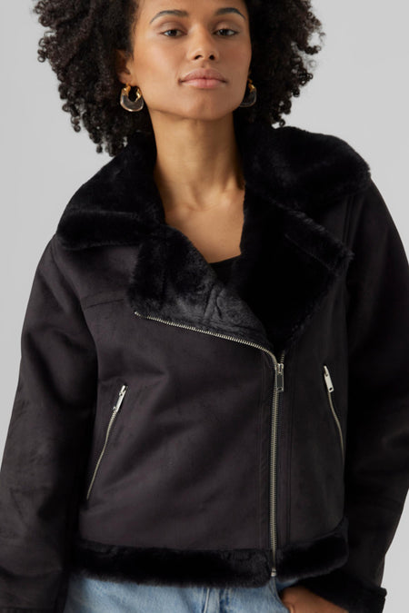 Manteau noir de VERO MODA avec doublure douce, manches longues et fermetures éclair argentées.