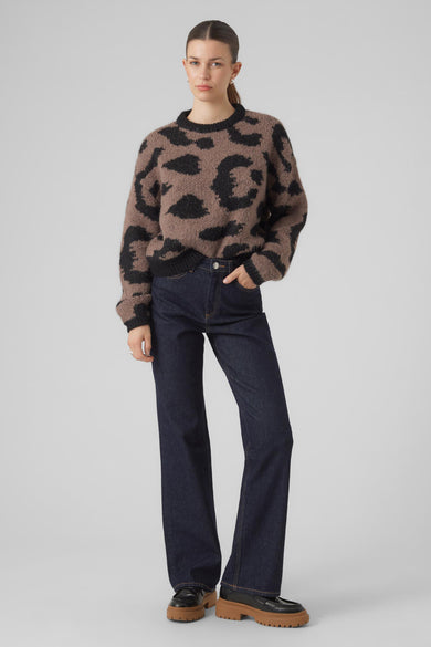 Pull marron avec col rond de VERO MODA, doté d'un motif léopard noir, associé à des jeans foncés et des chaussures à semelles épaisses.