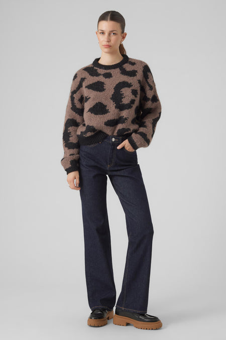 Pull marron avec col rond de VERO MODA, doté d'un motif léopard noir, associé à des jeans foncés et des chaussures à semelles épaisses.