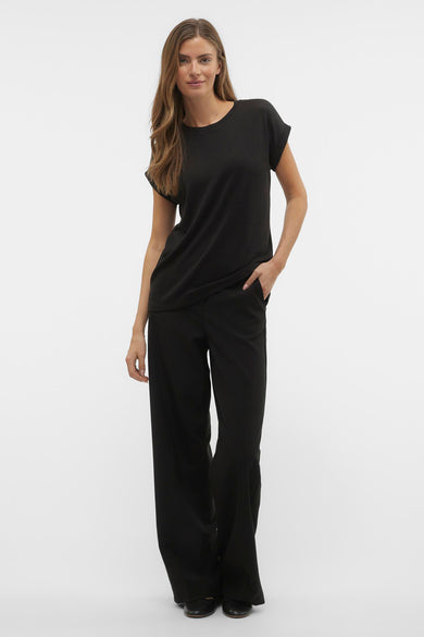 Zwart T-shirt met korte mouwen van VERO MODA®, gedragen met een zwarte pantalon en platte schoenen.
