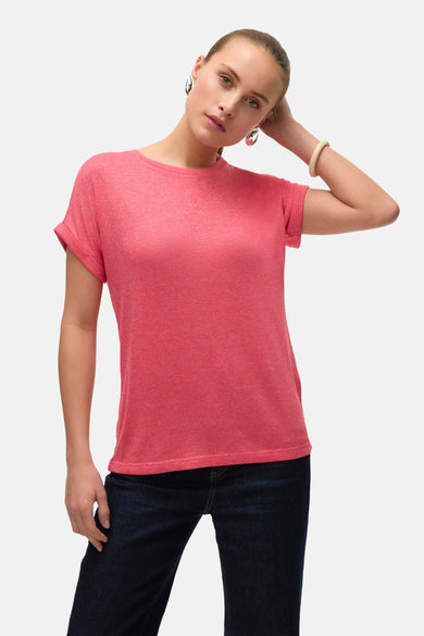 T-shirt rose à manches courtes de VERO MODA, avec une coupe décontractée associée à des jeans bleus foncés et des baskets blanches.