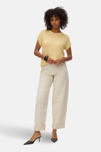 Geel T-shirt met korte mouwen van VERO MODA®, losvallend, met omgeslagen mouwen en gecombineerd met crèmekleurige broek en gepolka dotte pumps.