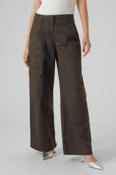 Pantalon vert de VERO MODA avec des poches, associé à un haut blanc et des escarpins argentés.