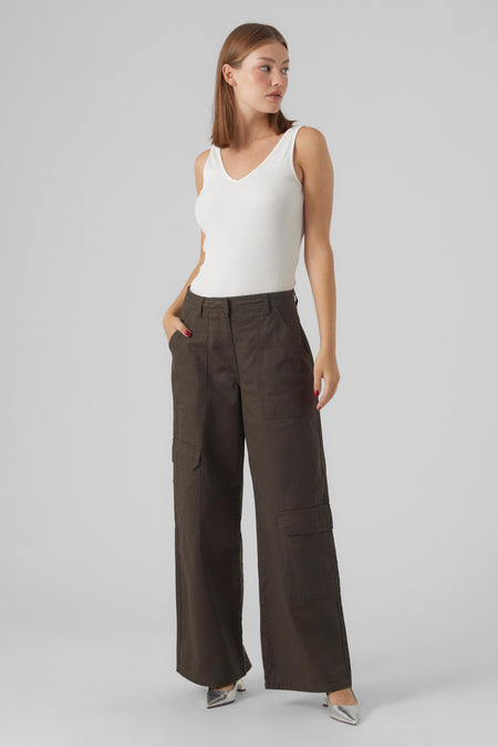 Pantalon vert de VERO MODA, avec des jambes larges et des poches cargo, associé à une chemise blanche et des escarpins argentés.