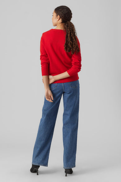 Rode kersttrui van VERO MODA, gezien van achteren, met lange mouwen en gecombineerd met jeans en hakken.
