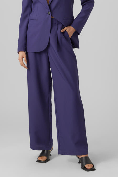 Pantalon bleu de Vero Moda, avec des jambes larges et porté avec un blazer coordonné.