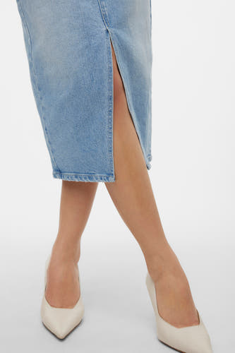 Jupe en denim bleu clair de VERO MODA, avec une fente, associée à des escarpins crème.