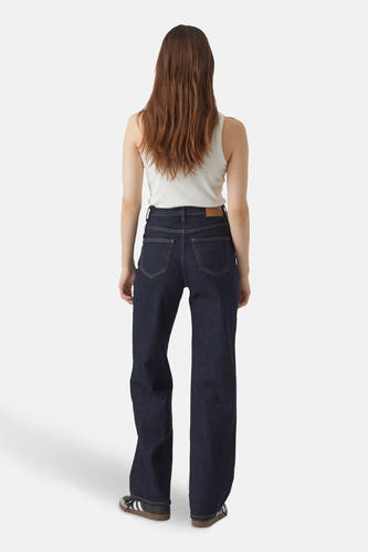 Jean décontracté de denim bleu marine par VERO MODA, vu de dos, avec un chemisier blanc et des baskets Adidas.