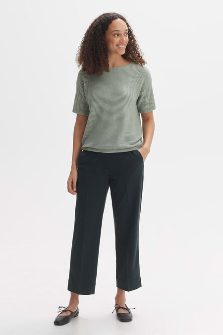 Groen T-shirt met korte mouwen van OPUS met wafeltextuur, gecombineerd met donkere broek en ballerina's.