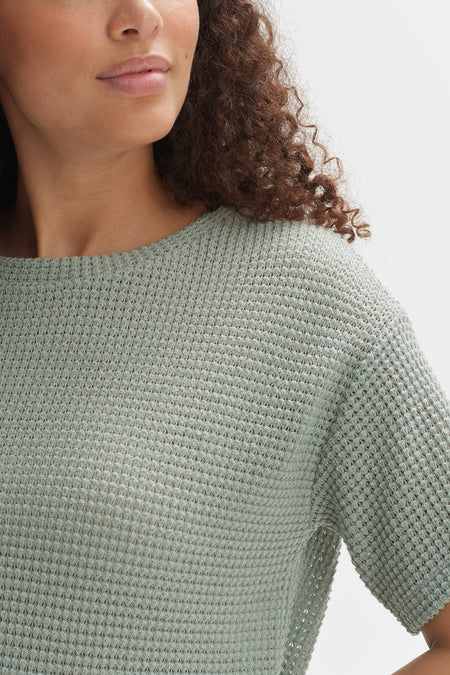 Lichtgroen T-shirt met korte mouwen van OPUS met een fijn wafelpatroon, gedragen door een model met krullend haar.