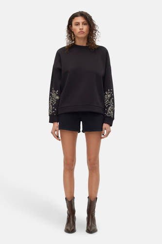 Short noir de VERO MODA, avec des poches arrière et un étiquette sur la ceinture.