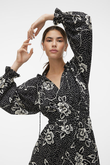 Jupe noire courte de VERO MODA, avec des manches longues, un imprimé fleuri et une taille structurée.