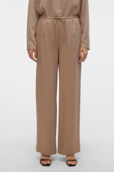 Jean en argent de VERO MODA, avec des jambes larges et une ceinture élastique, porté avec des sandales.