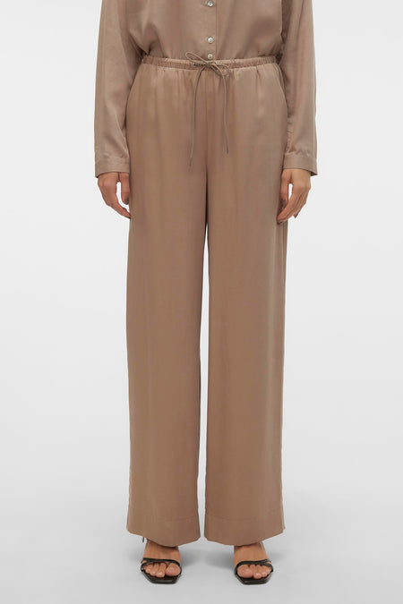 Jean en argent de VERO MODA, avec des jambes larges et une ceinture élastique, porté avec des sandales.