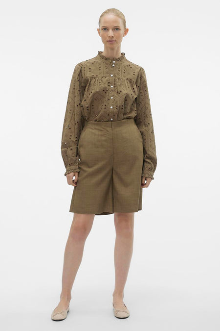 Short brun de VERO MODA, associé à une blouse brodée avec des manches longues et des baskets.