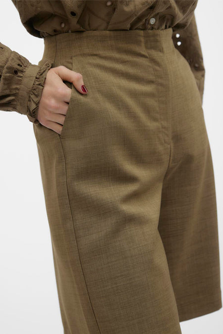 Short brun de VERO MODA, avec une main dans la poche et une blouse coordonnée.