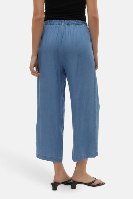 Pantalon bleu de VERO MODA® avec ce taille élastique, des jambes larges et des sandales noires.