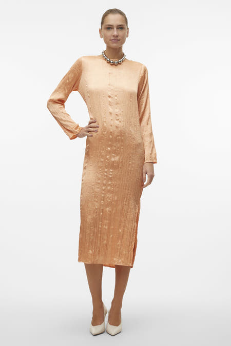 Robe orange à longues manches de VERO MODA, avec une subtile texture et une chaîne d'argent.
