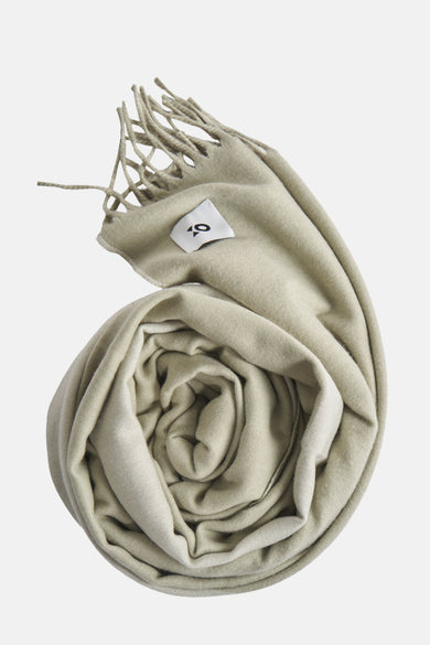 Groene wintersjaal van OPUS, opgerold weergegeven met franjes en een label.