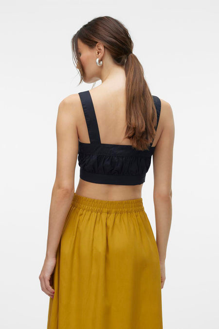 Blouse noire de VERO MODA, avec des bretelles et une taille froncée, associée à une jupe marron.