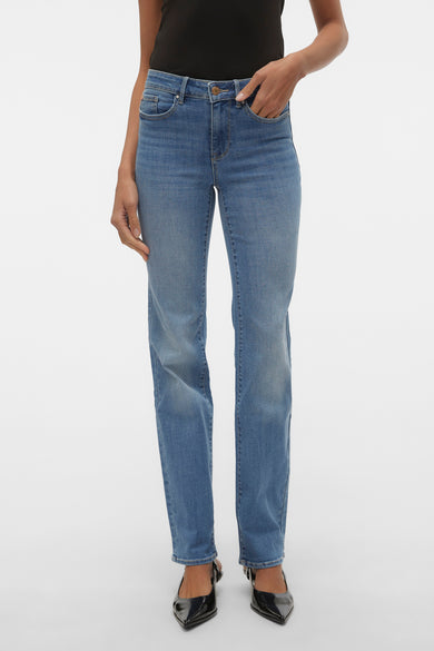 Jean droit en denim bleu de VERO MODA®, porté par un modèle avec des chaussures noires.