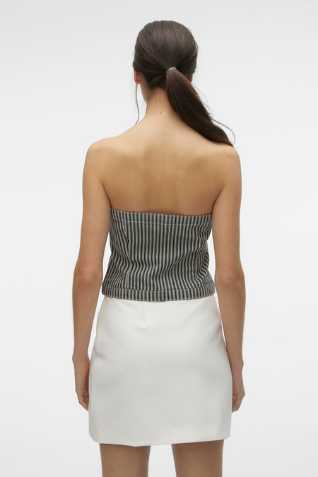 Blauwe blouse van Vero Moda, met een gestreept patroon, gedragen met een witte rok, gezien van achteren.
