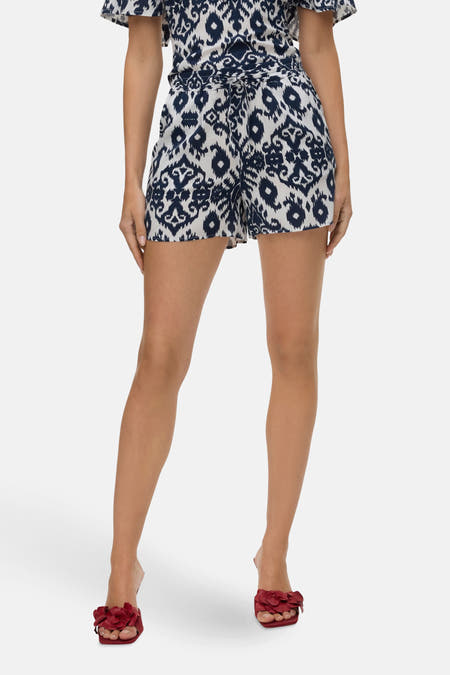 Short bleu de VERO MODA avec motif ikat, cintré à la taille et associé à des sandales rouges.
