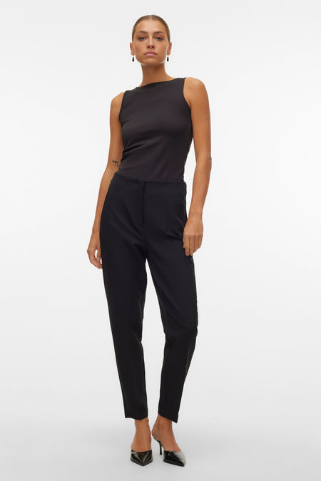 Pantalon noir de VERO MODA, porté avec un haut noir et des escarpins noirs.