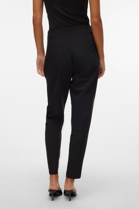 Pantalon noir de VERO MODA, vu de derrière, associé à une chemise noire et des talons.